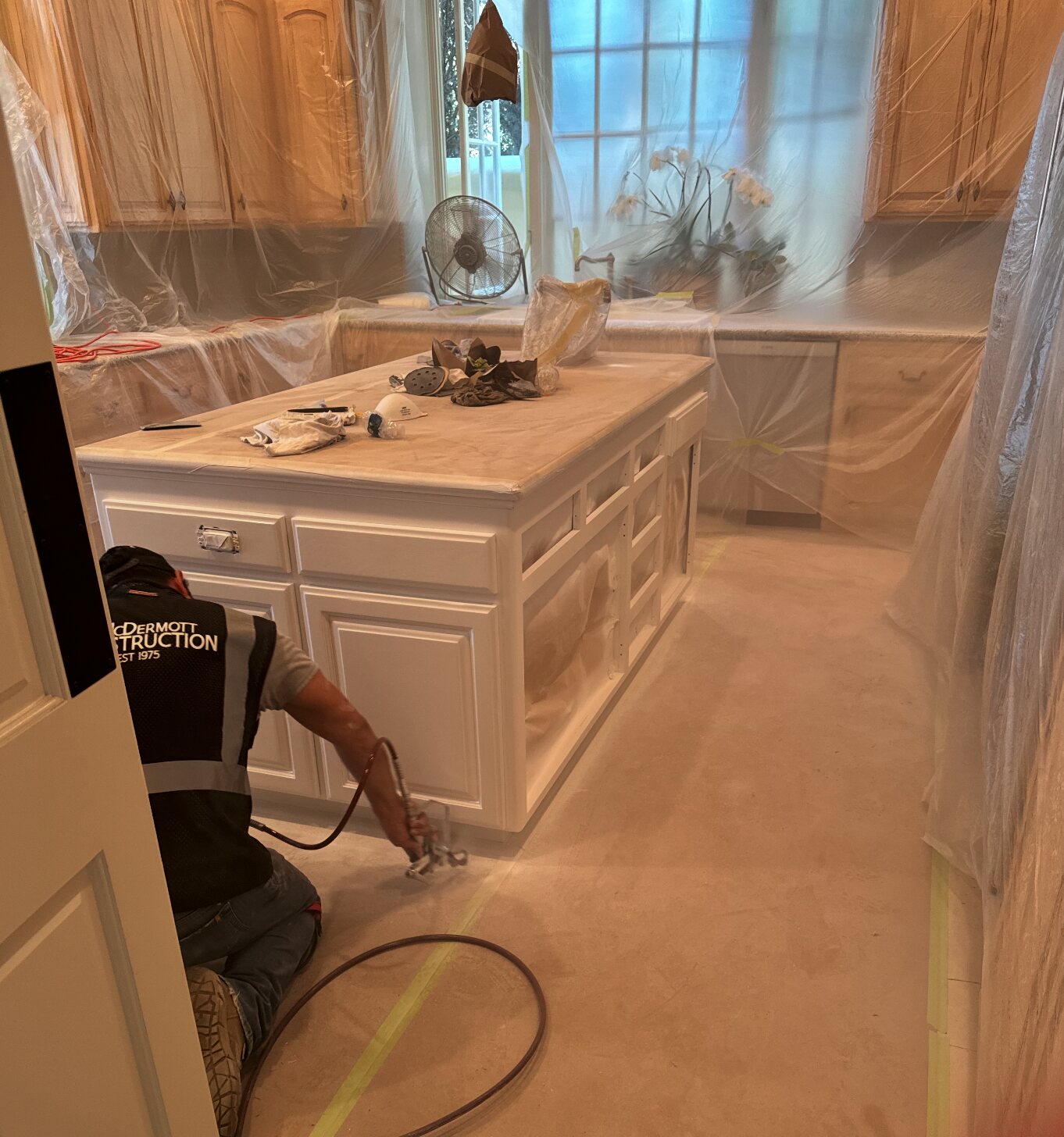 A McDermott Construction craftsman refinishing custom cabinetry on site