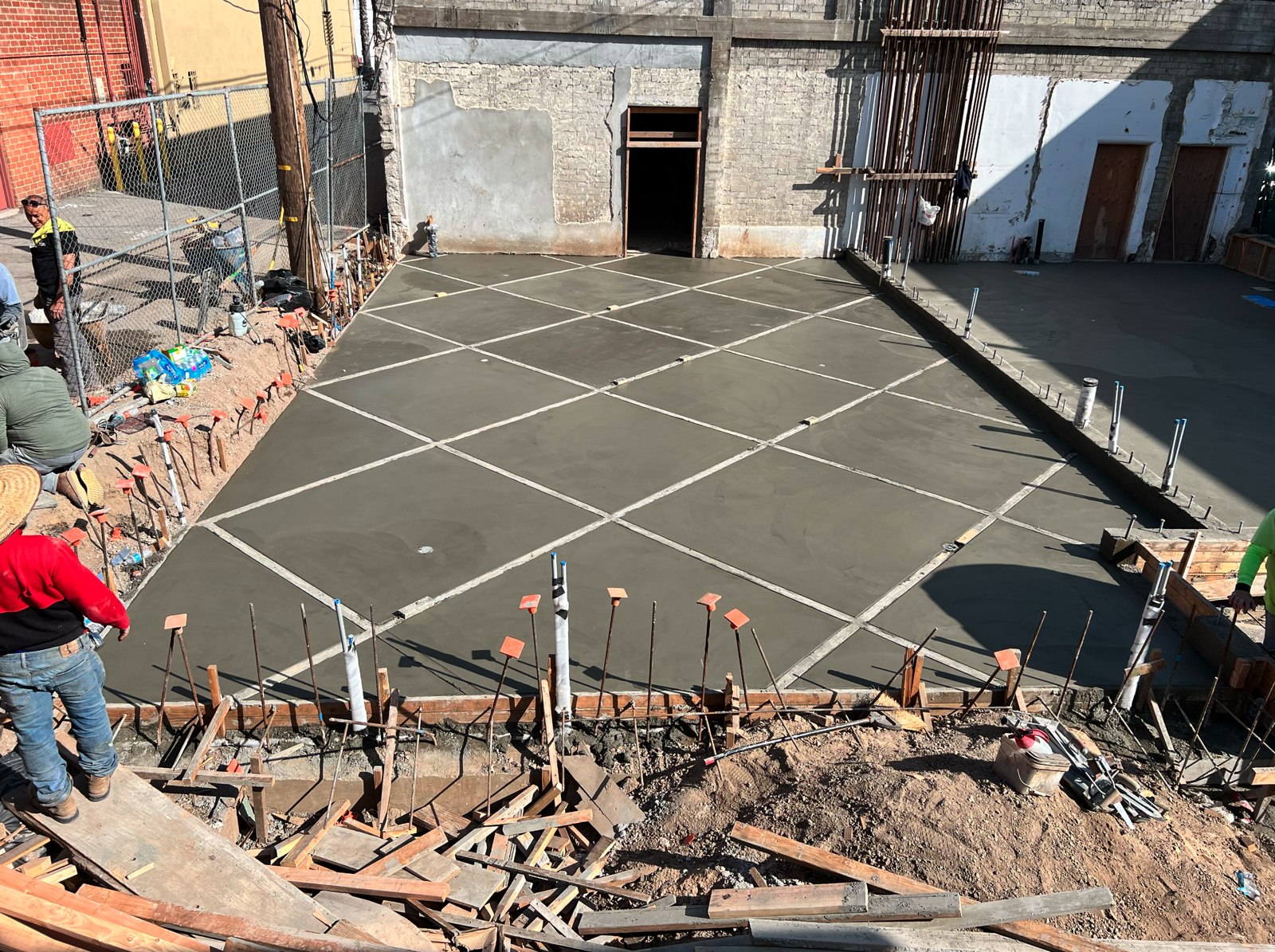 A new foundation being poured — rebar grid and formwork on a ground-up McDermott Construction build