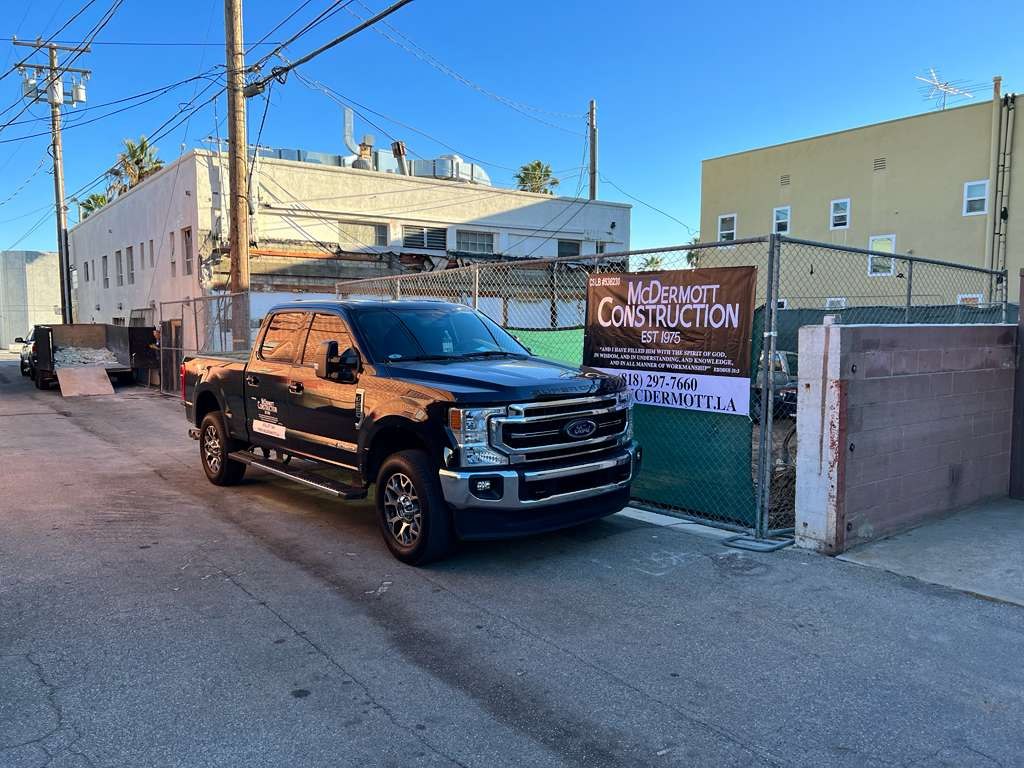 McDermott Construction truck and jobsite banner at a ground-up build
